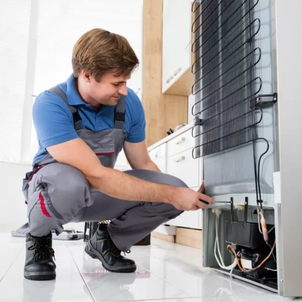 Técnico consertando geladeira